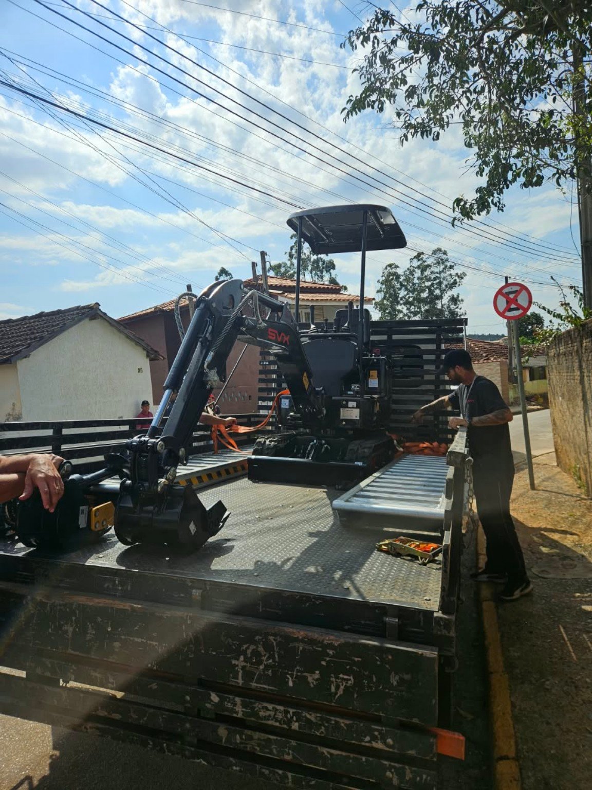 Mini escavadeira da empresa chegando ao local do serviço
