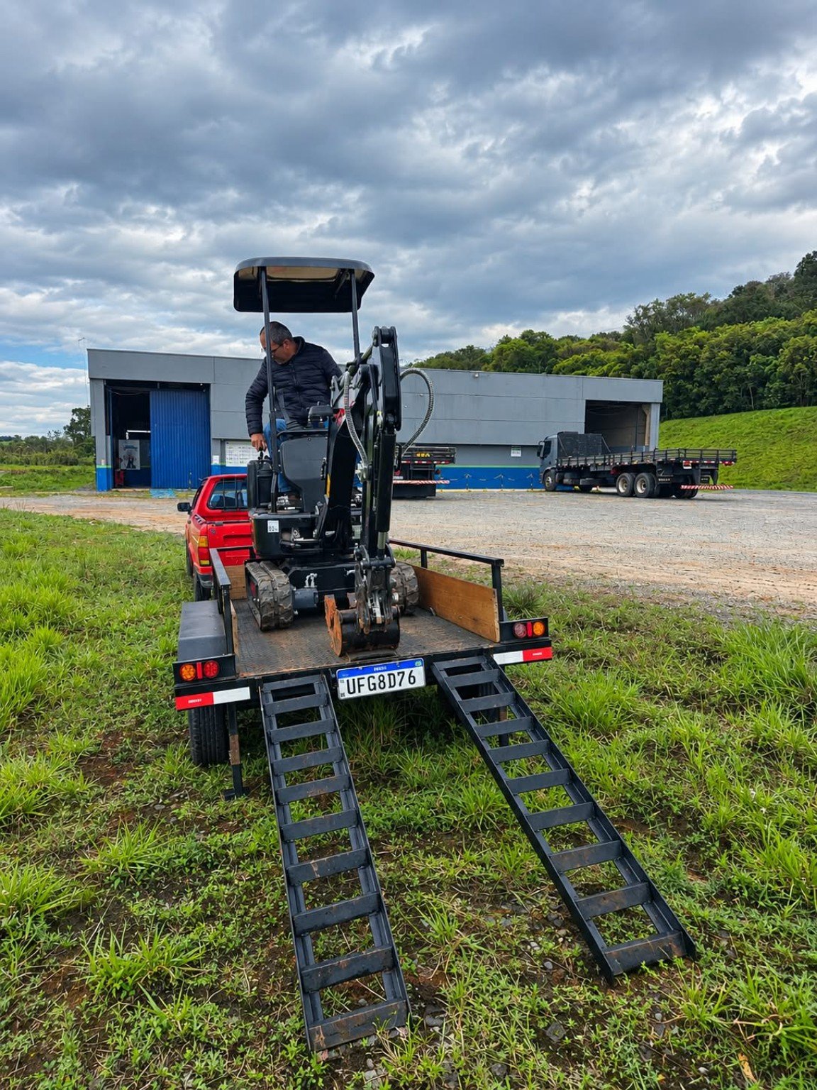 Mini escavadeira sendo preparada para transporte